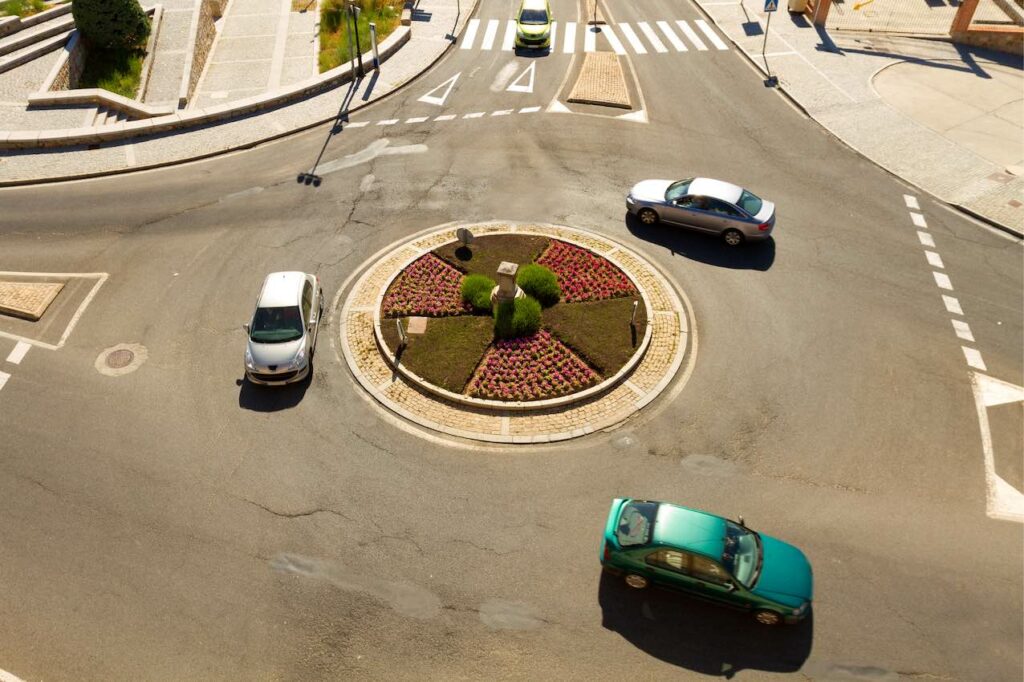 Des voitures circulent autour d'un rond-point.