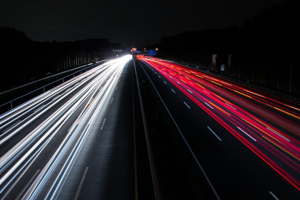 Feux rouges et blancs de voitures sur une route.