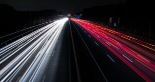 Feux rouges et blancs de voitures sur une route.